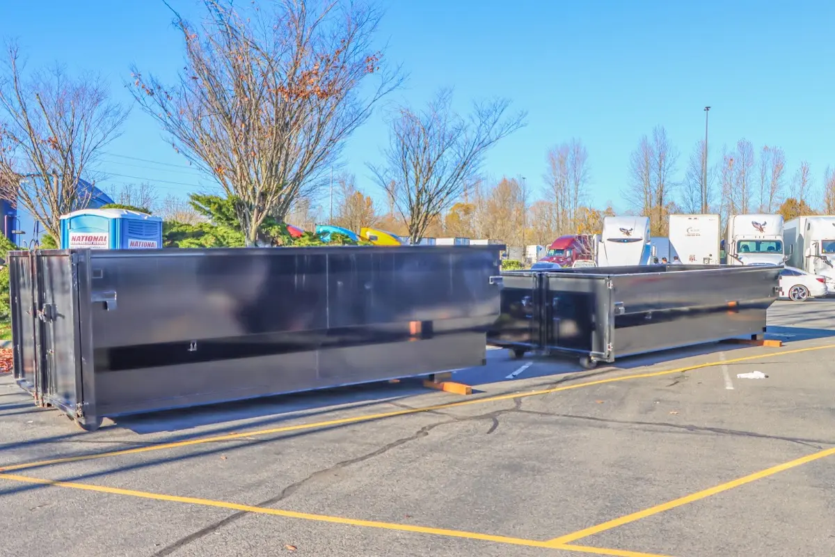 Professional dumpster rental service with roll-off container on residential driveway in Groton